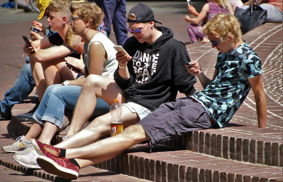 Teenage boys looking at their phones