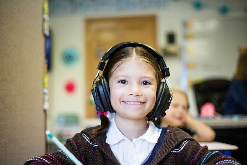Young girl with big headphones at school