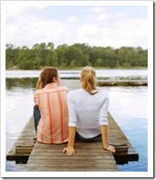 Couple sitting on a pier by the water