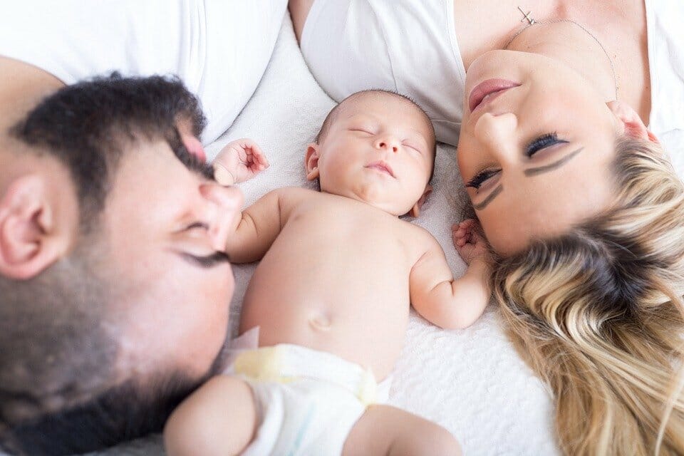 Happy parents with their sleeping baby