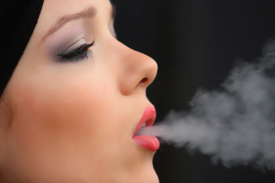 Teen girl blowing out smoke