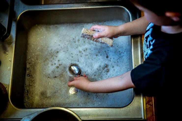 Young child washing dishes