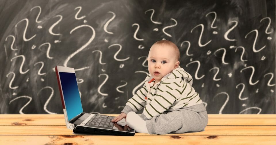 Baby with laptop surrounded by question marks