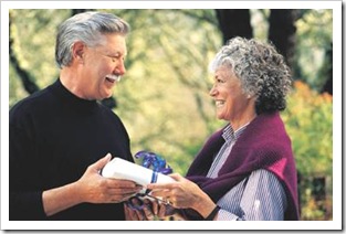 Old man giving old woman a gift