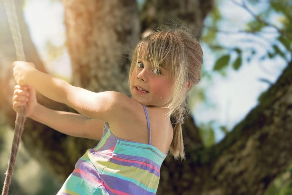 Girl swinging from a rope