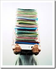 Personal holding a tall stack of folders