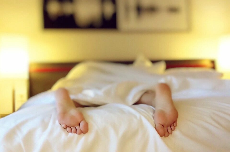 Person's feet sticking out of bed