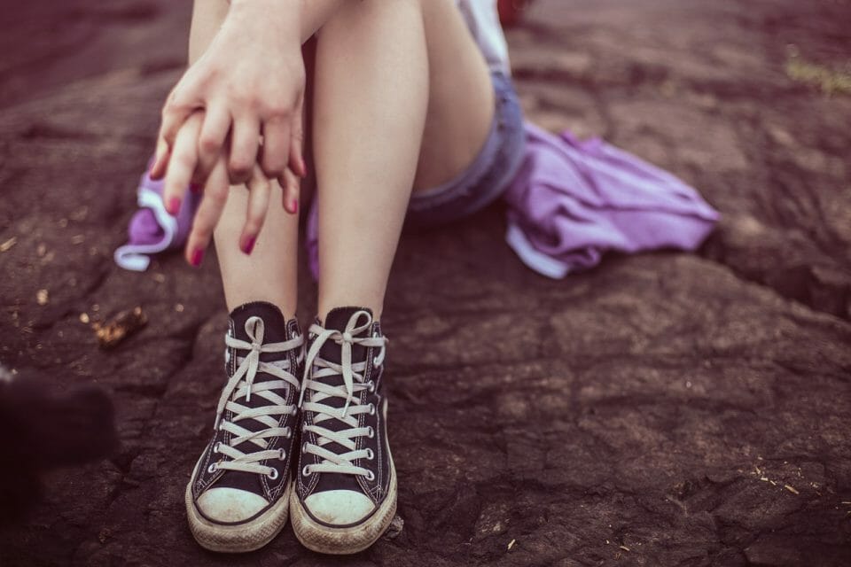 Teen girl's legs in Converse shoes