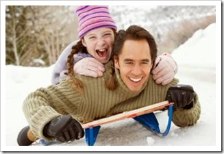 Father sledding with daughter