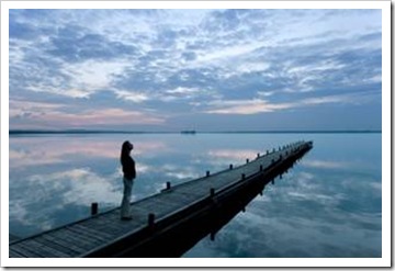 Woman on long pier at dusk