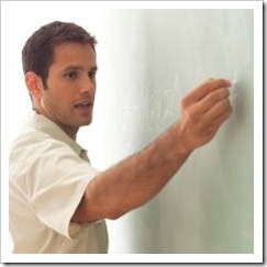 Young male teacher writing on board