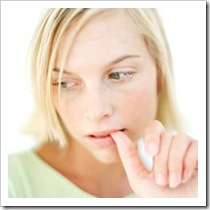 Young woman biting her nail