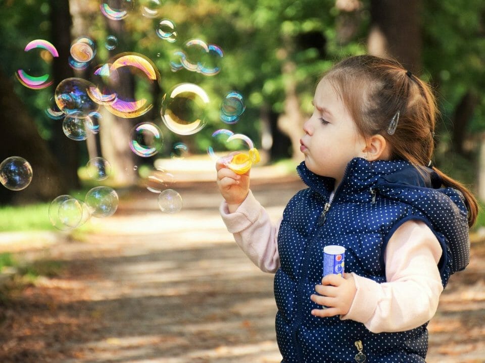 Little girls blowing bubbles and making happy childhood memories