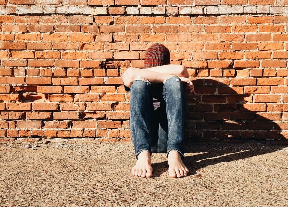 Teen sitting alone head down