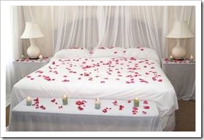 Bed with flower petals and candles