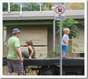 Kids on train next to no climbing sign