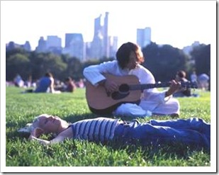 Man playing guitar to a girl at a part