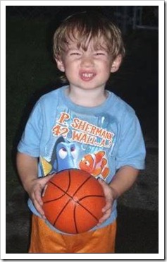 Boy holding a basketball and making a face