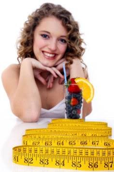 Young woman with tape measure and fruit salad