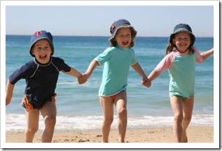 Happy kids running on the beach holding hands