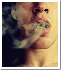 Young man blowing smoke