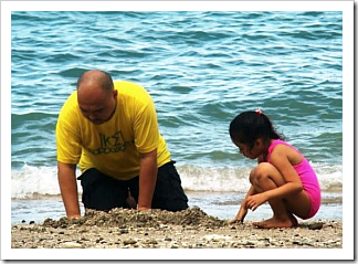 Father and daughter in the sand
