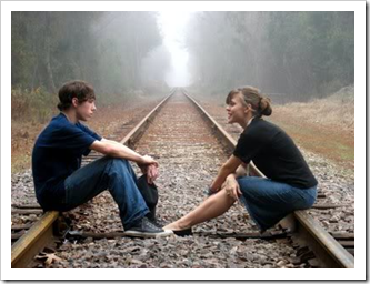 Teenagers talking on railroad tracks