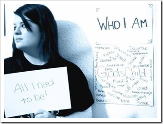 Girl holding a sign saying "Who I am - All I need to be"