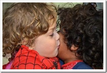 White boy kissing a black boy on the cheek