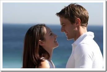 Couple looking into each other's eyes on the beach