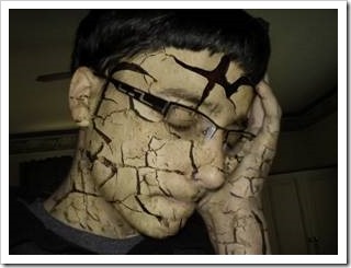 Boy with a face of cracked earth skin