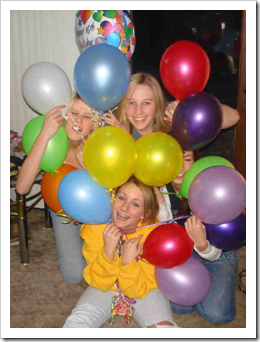 Teenage girls peeping through a bunch of balloons