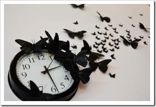 Black clock surrounded by black butterflies