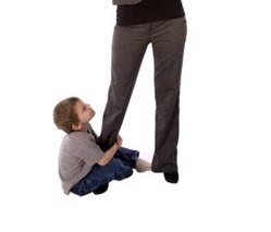 Boy clinging to mother's leg