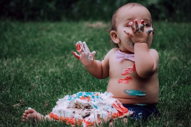 Baby about to eat white and blue icing-covered cake