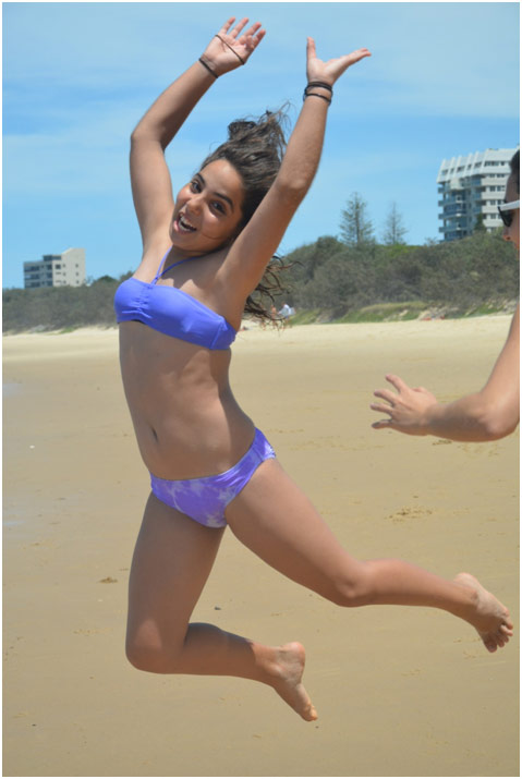 Teenage girl leaping on the beach