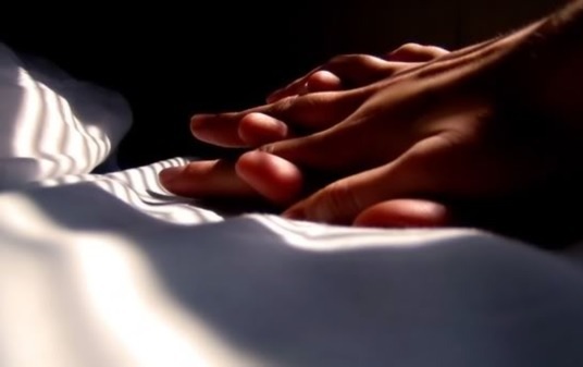 Two hands clasped on a sheet - good sex requires a good connection