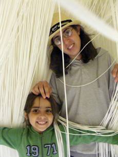 Tsoof and Noff in a museum exhibit with strings hanging from the ceiling