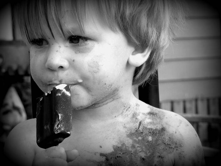Little dirty boy eating ice cream
