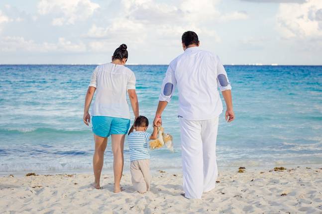 Parents and toddler walking on a beach