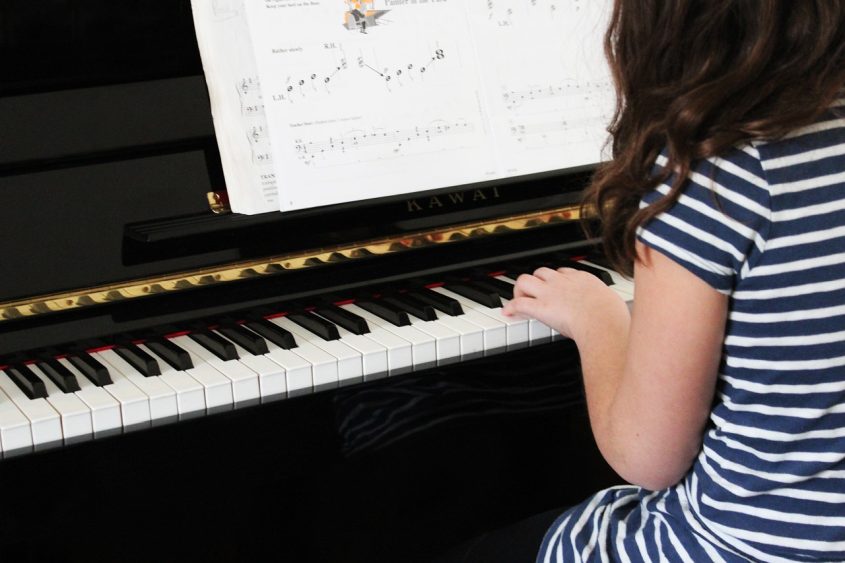 Girl with the auditory communication style playing the piano