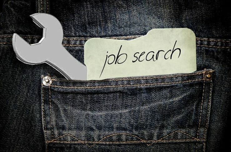 Wrench and a note saying "job search" in the back pocket of jeans
