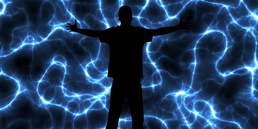 Silhouette of man with arms spread out over an electric storm