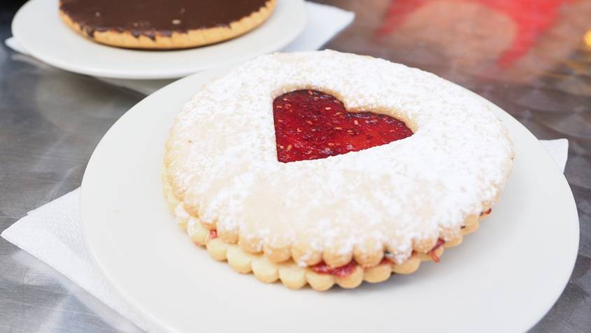 Cookie with a heart-shaped hole showing jam