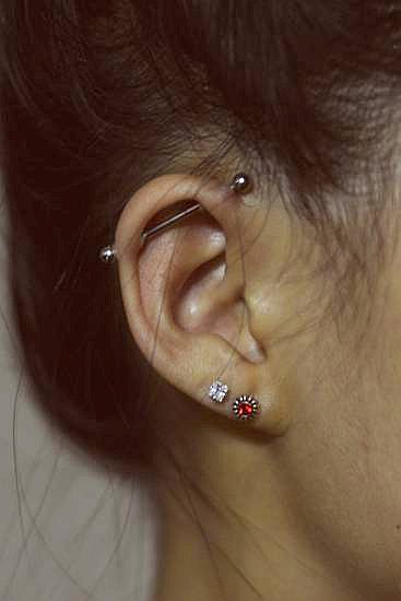 Metal bar through ear piercing