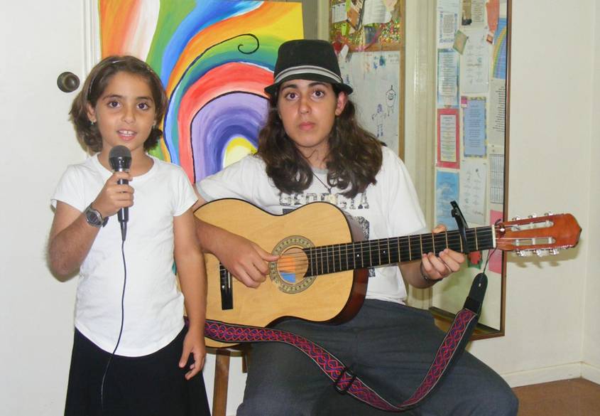 Noff with a microphone and Tsoof on guitar