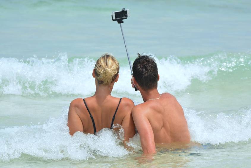 Man taking selfie of himself and his partner on the beach