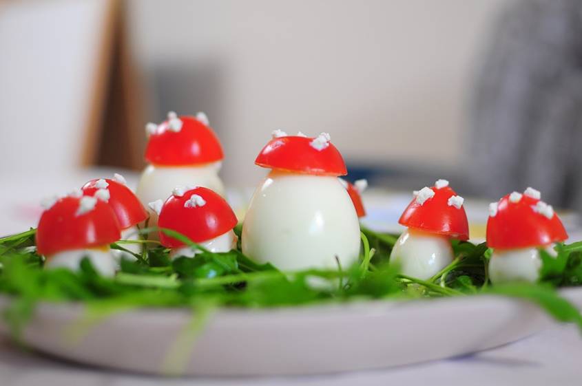 Hard boiled eggs decorated with tomato pieces to look like mushrooms