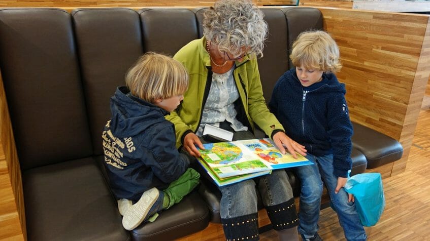 Grandmother reading a book to her grandchildren