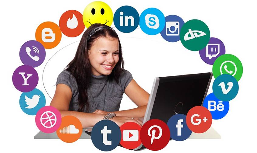 Young woman at her laptop surrounded by social media icons